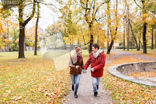 Image of happy young couple running in autumn park