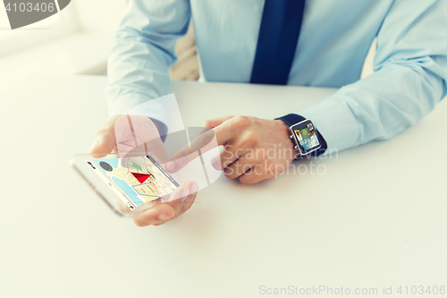 Image of close up of hands with smart phone and watch