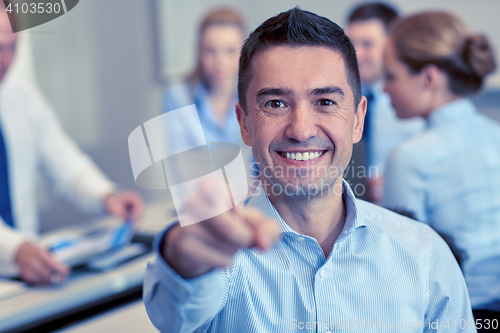 Image of group of smiling businesspeople meeting in office