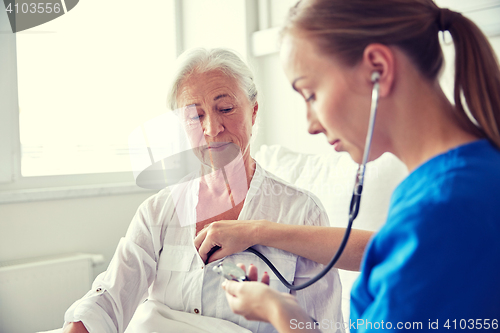 Image of nurse with stethoscope and senior woman at clinic