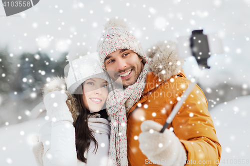 Image of happy couple taking selfie by smartphone in winter