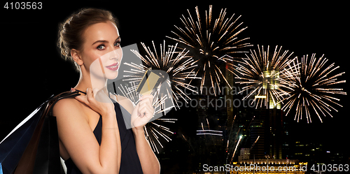 Image of woman with bank card and shopping bags on firework