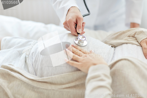 Image of doctor with stethoscope and pregnant woman