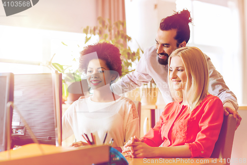 Image of happy creative team with computer in office