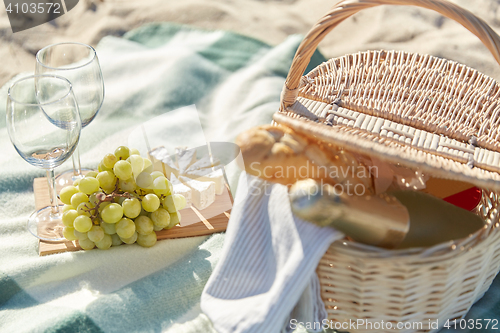 Image of picnic basket with wine glasses and food on beach