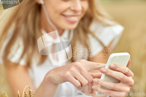 Image of close up of woman with smartphone and earphones