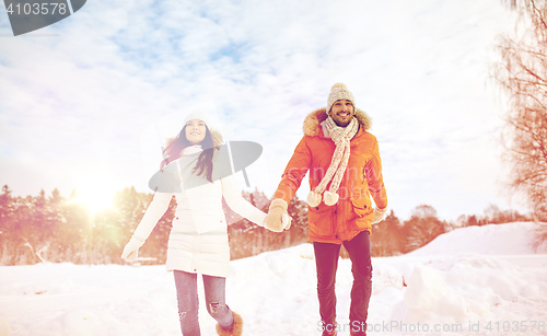 Image of happy couple running in winter snow