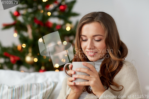 Image of happy woman with cup of tea at home for christmas