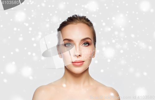 Image of beautiful young woman face over snow