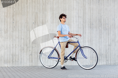 Image of young hipster man riding fixed gear bike