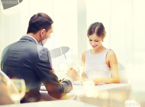 Image of smiling couple eating dessert at restaurant