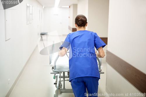 Image of nurse carrying hospital gurney to emergency room