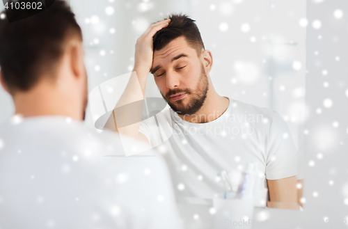 Image of sleepy young man in front of mirror at bathroom