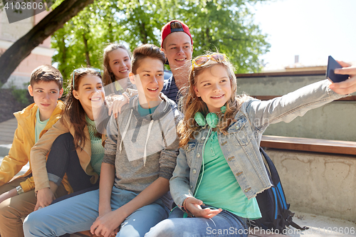 Image of happy teenage students taking selfie by smartphone