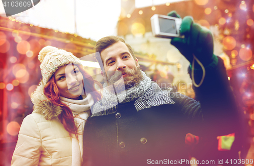 Image of couple taking selfie with smartphone in old town