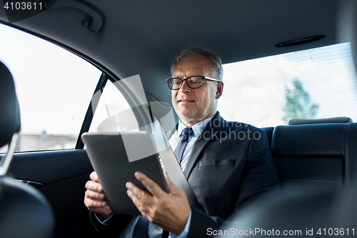 Image of senior businessman with tablet pc driving in car