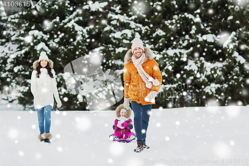 Image of happy family with sled walking in winter forest