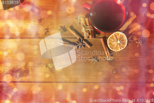 Image of tea cup with winter spices on wooden table