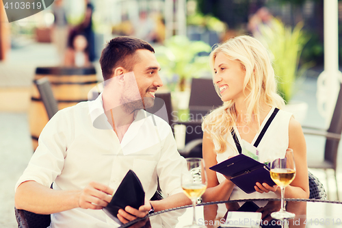 Image of happy couple with wallet paying bill at restaurant