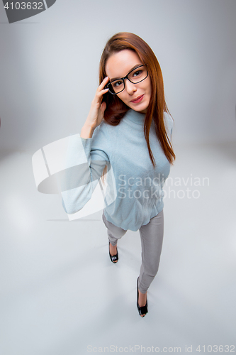 Image of The smiling young business woman on gray background