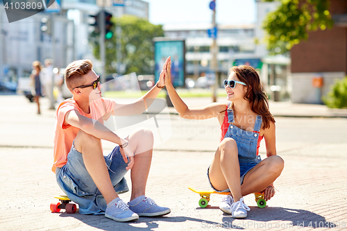 Image of teenage couple with skateboards on city street