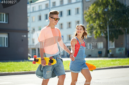 Image of teenage couple with skateboards on city street