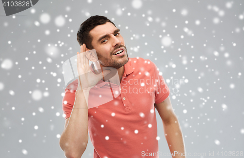 Image of man having hearing problem listening to something