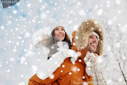 Image of happy couple having fun over winter background