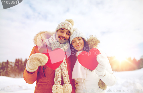 Image of happy couple with red hearts over winter landscape