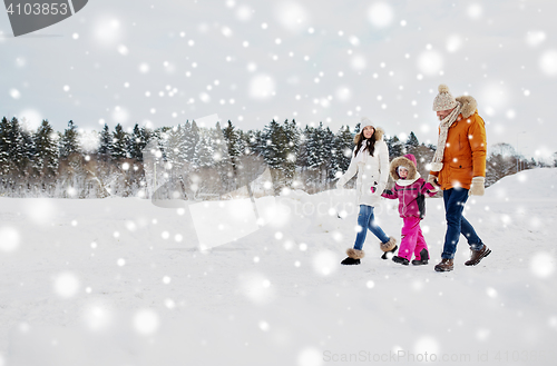 Image of happy family in winter clothes walking outdoors