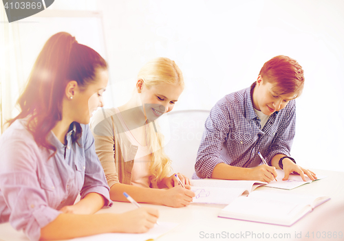 Image of smiling students with notebooks at school