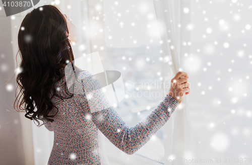 Image of close up of woman opening window curtains