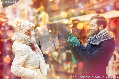 Image of couple taking selfie with smartphone in old town