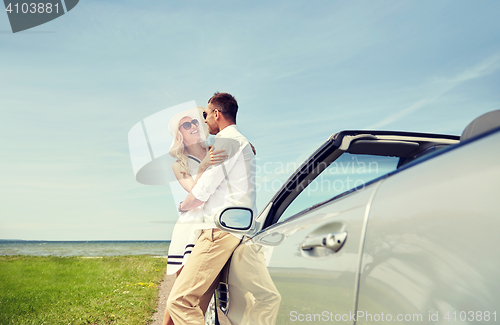 Image of happy couple hugging near cabriolet car at sea