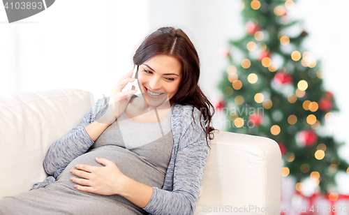 Image of happy pregnant woman calling on smartphone at home