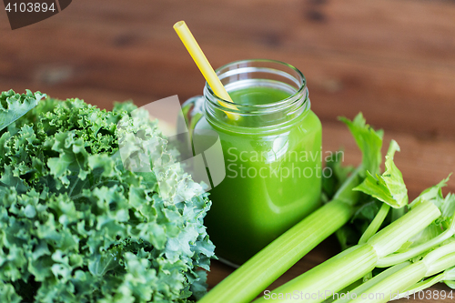 Image of close up of jug with green juice and vegetables