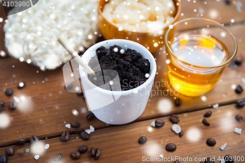 Image of homemade coffee scrub in cup and honey on wood