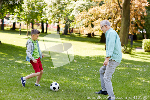 Image of old man and boy playing football at summer park