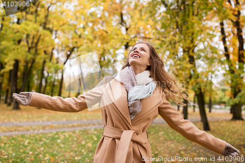 Image of beautiful happy young woman walking in autumn park