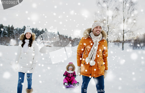 Image of happy family with sled walking in winter outdoors