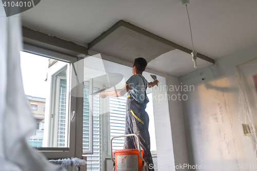 Image of Plasterer renovating indoor walls and ceilings. Finishing works.