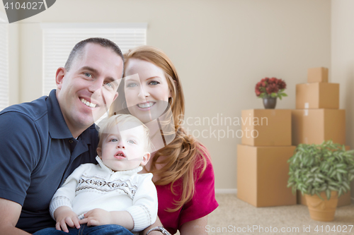 Image of Young Military Family in Empty Room with Packed Boxes