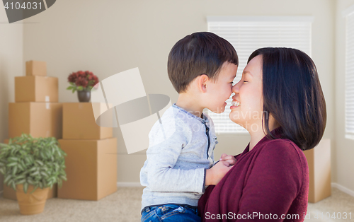 Image of Mixed Race Chinese Mother and Child in Empty Room with Packed Mo