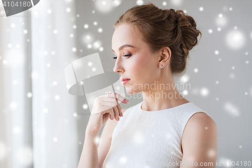 Image of beautiful woman in white with diamond jewelry