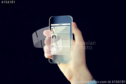 Image of close up of male hand with transparent smartphone