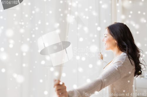 Image of close up of woman opening window curtains