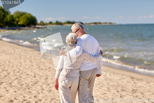 Image of happy senior couple hugging on summer beach