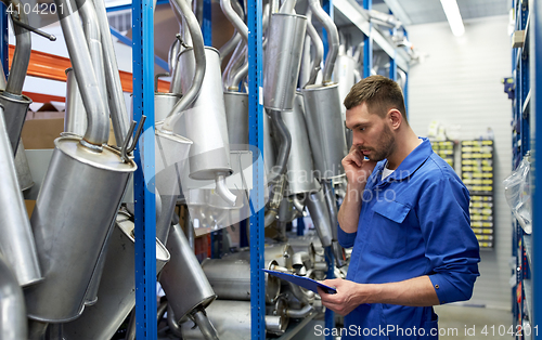 Image of auto mechanic calling on phone at car shop