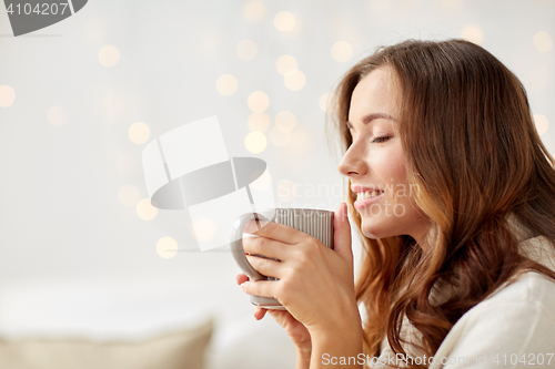 Image of happy woman with cup of tea or coffee at home