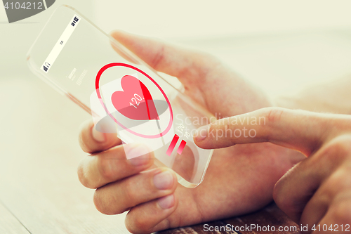 Image of close up of hand with heart rate on smartphone